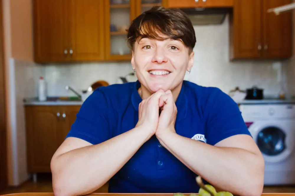 A Hope Harbour support worker smiling in a home kitchen.